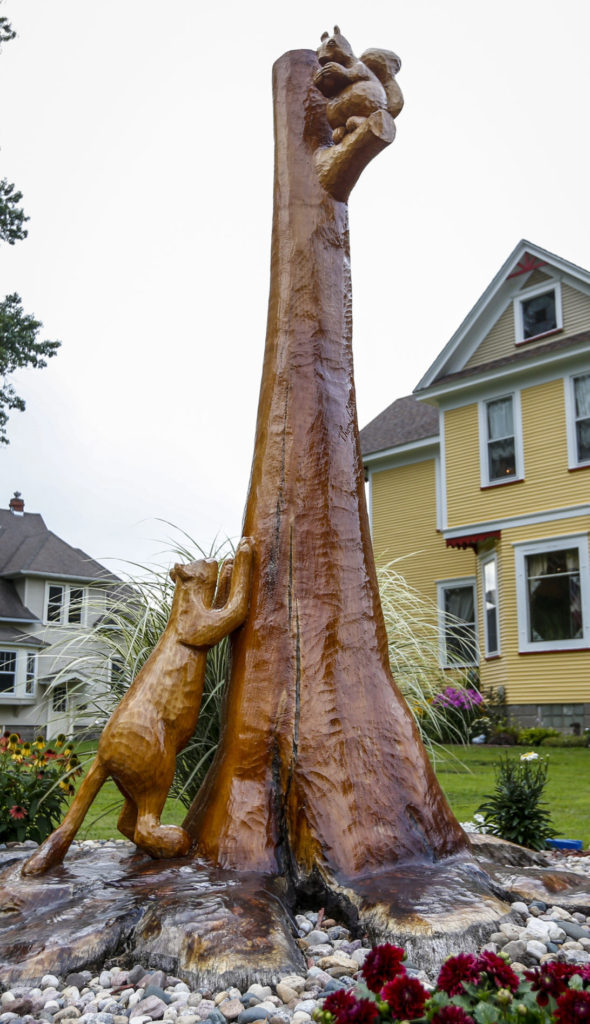statue of a tree with a squirrel and a wild cat made out of Oak
